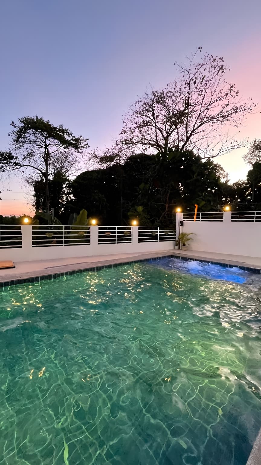 The pool at Sonia's Loft at dusk, with the glass doors of the loft folded open behind it